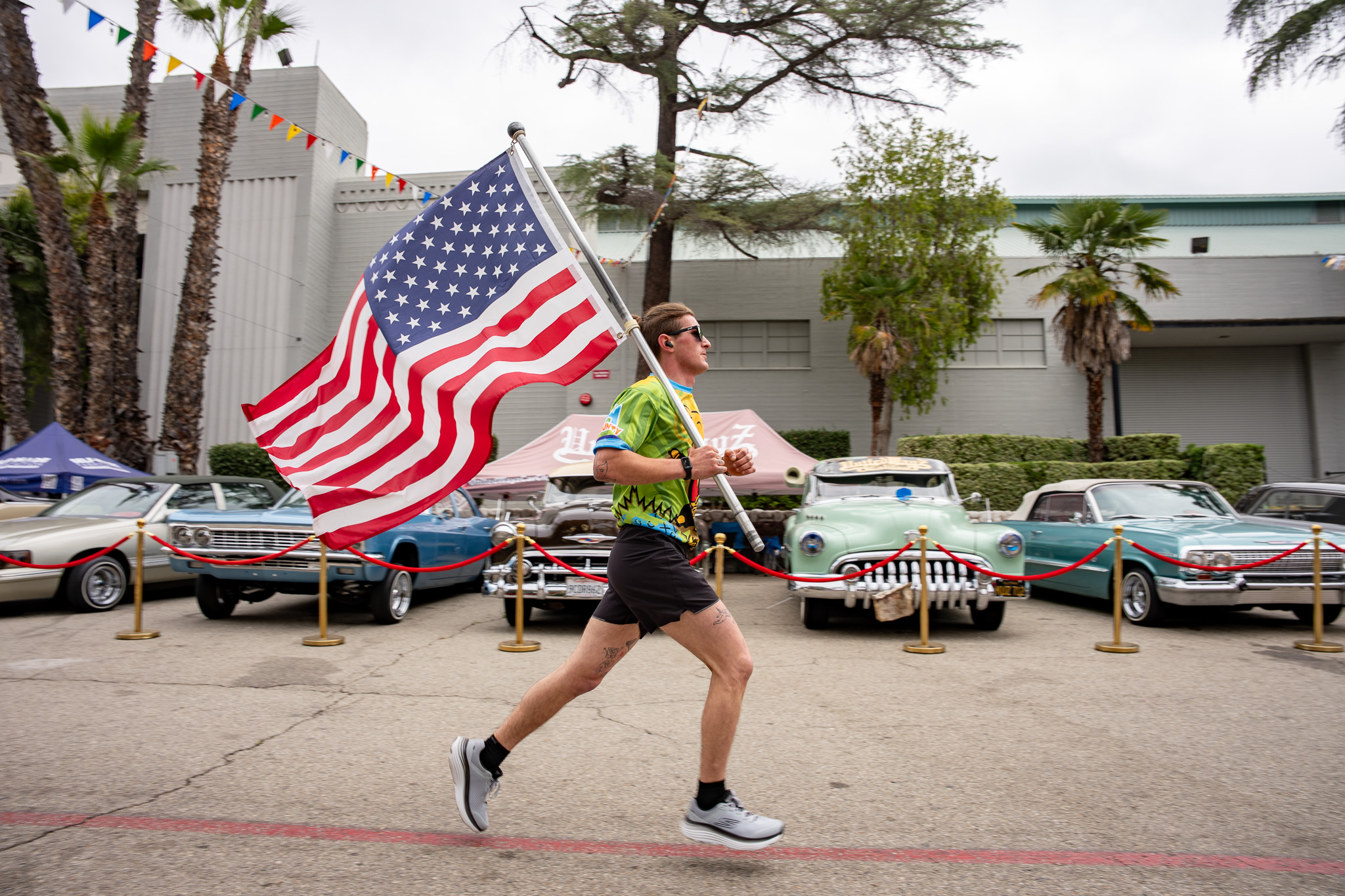 Runner with American flag at a classic car show
